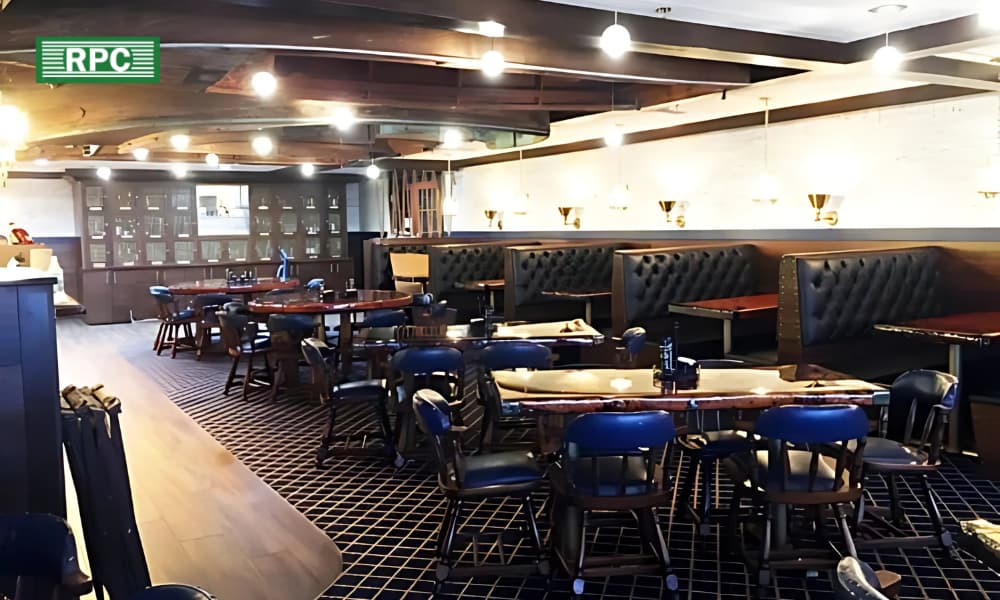 A well-constructed restaurant interior in dark wood and cream tones with blue highlight furniture.