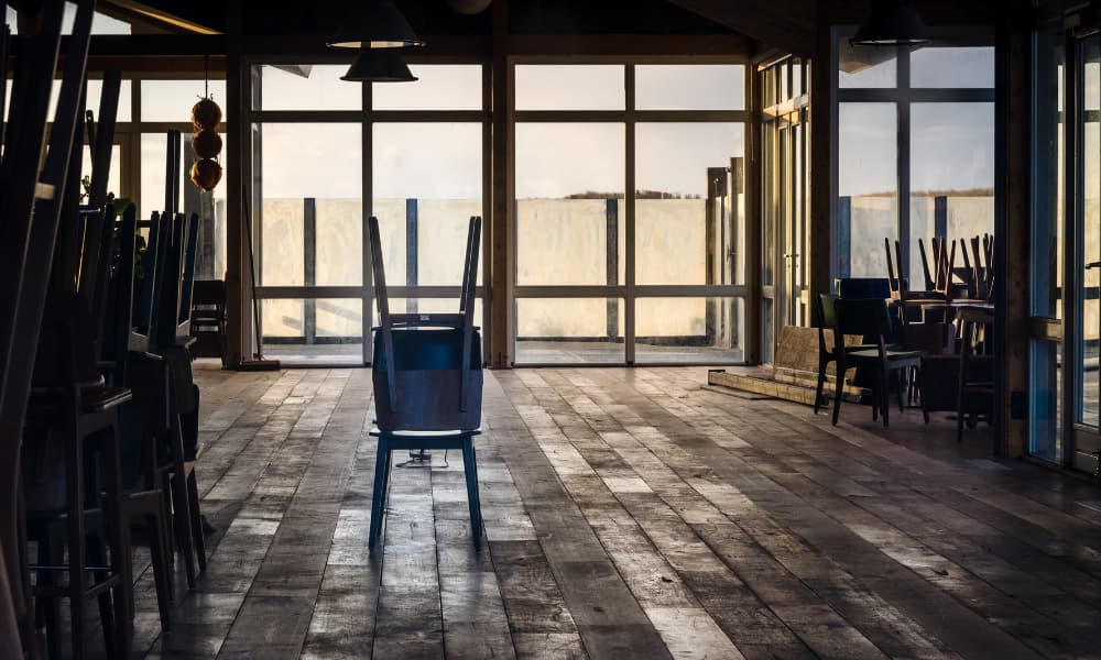 A closed restaurant with chairs upturned on tables.