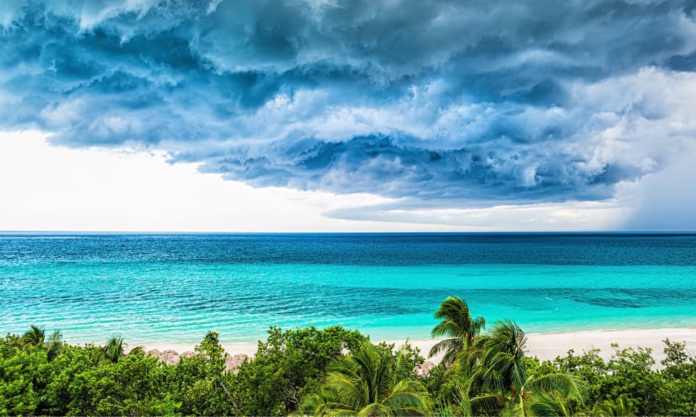 Storm clouds gathering over a tropical coastline.